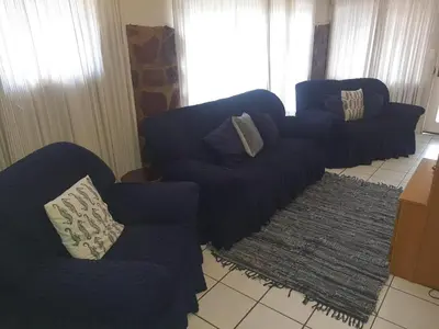 a living room with blue couches and a rug at Cottage 2 at Cynthias Country in Hartbeespoort