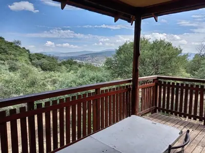 a wooden porch with a table and chairs on it at Snowy Owl in Burgersfort