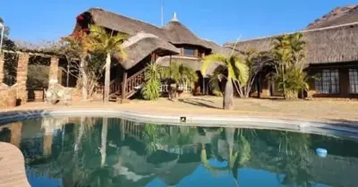 a house with a swimming pool in front of it at Snowy Owl in Burgersfort