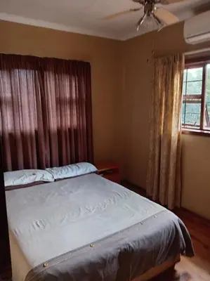 a bedroom with a bed and a ceiling fan at Snowy Owl in Burgersfort