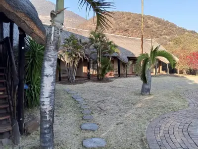 a resort with palm trees and a building at Snowy Owl in Burgersfort