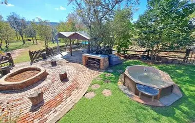 a backyard with a fire pit in the grass at Inniberg Nylstroom in Nylstroom
