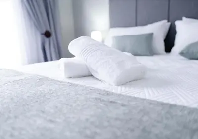 a white bed with white sheets and pillows on it at Viata Luxe Guesthouse in Phalaborwa