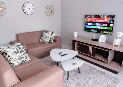a living room with a couch and a tv at Viata Luxe Guesthouse in Phalaborwa