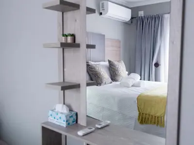 a bedroom with a bed with a mirror in it at Viata Luxe Guesthouse in Phalaborwa