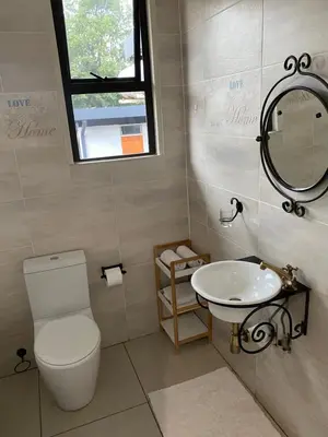 a bathroom with a toilet and a sink at Bridgelamour Guest house1 in Hartbeespoort