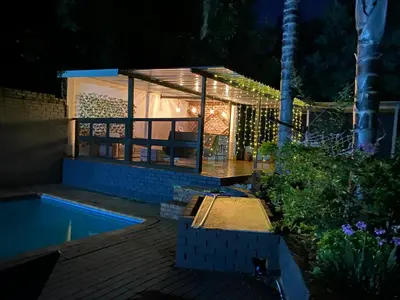 a house with a swimming pool at night at Bridgelamour Guest house1 in Hartbeespoort