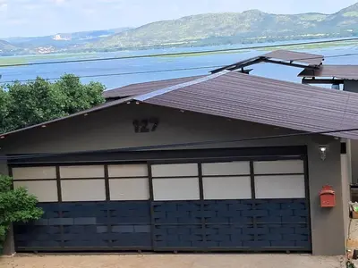 a garage door with a brown roof on a house at THE GALLARY INN, Kosmos, Hartbeespoort in Hartbeespoort