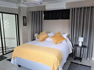 a bedroom with a bed with yellow sheets and pillows at THE GALLARY INN, Kosmos, Hartbeespoort in Hartbeespoort
