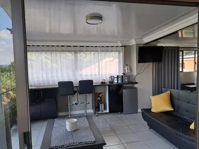 a living room with a couch and a table at THE GALLARY INN, Kosmos, Hartbeespoort in Hartbeespoort
