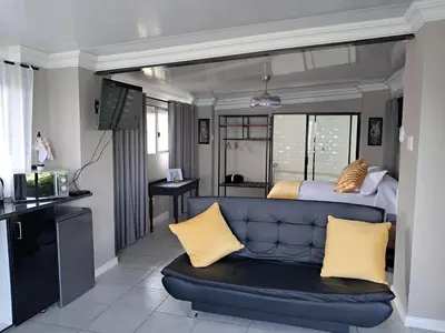 a living room with a couch and a bed at THE GALLARY INN, Kosmos, Hartbeespoort in Hartbeespoort