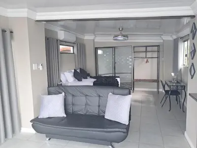 a living room with a bed and a couch at THE GALLARY INN, Kosmos, Hartbeespoort in Hartbeespoort