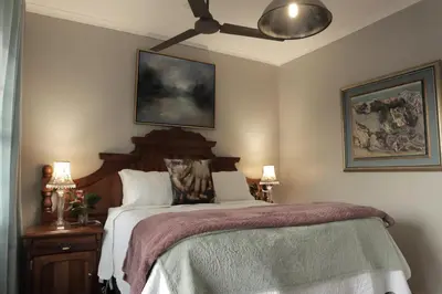 a bedroom with a bed with a ceiling fan at Highveld Guesthouse in Centurion