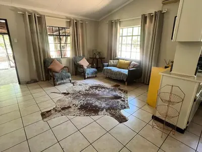 a living room with a table on a tiled floor at Hello Kruger Hideaway in Marloth Park