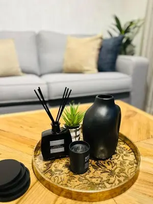 a coffee table with a black vase on a tray at Riamus Luxury Apartment in Midrand