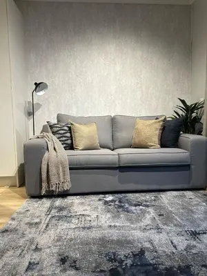 a gray couch in a living room with a rug at Riamus Luxury Apartment in Midrand