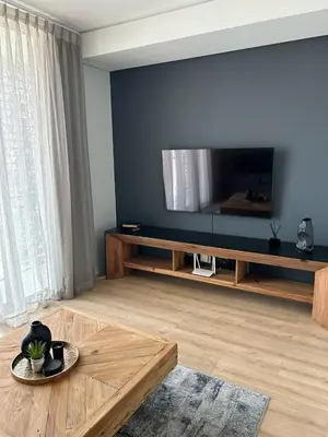 a living room with a large flat screen tv on a wall at Riamus Luxury Apartment in Midrand