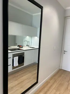 a mirror in a kitchen with a sink and a stove at Riamus Luxury Apartment in Midrand