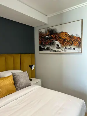 a bedroom with a bed and a painting on the wall at Riamus Luxury Apartment in Midrand