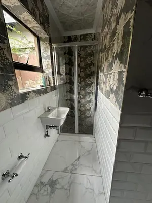 a bathroom with a sink and a shower at Wayside Guesthouse in Witbank