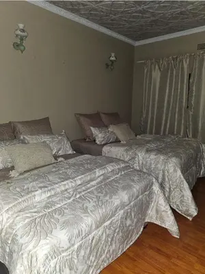 a bedroom with two beds and a window at Wayside Guesthouse in Witbank
