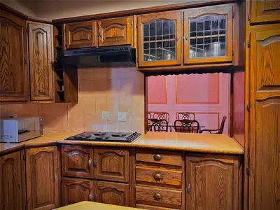 a kitchen with wooden cabinets and a stove top oven at Wayside Guesthouse in Witbank