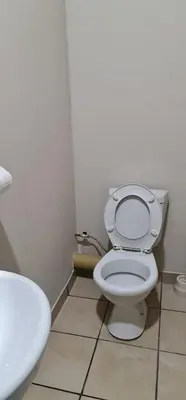 a bathroom with a white toilet and a sink at BINU motel in Secunda