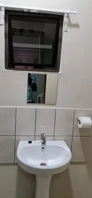 a bathroom with a white sink and a mirror at BINU motel in Secunda