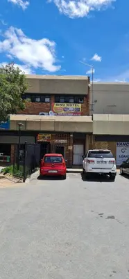 two cars parked in a parking lot in front of a building at BINU motel in Secunda