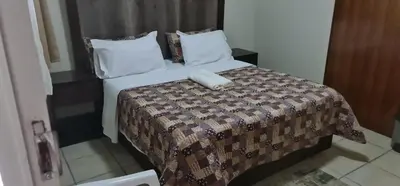 a hotel room with a bed with a phone on it at BINU motel in Secunda