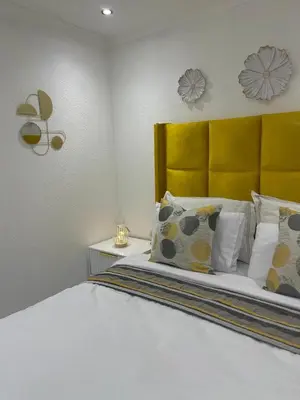 a bedroom with a bed with a yellow headboard and pillows at Beautiful Customized Hide Out in Centurion