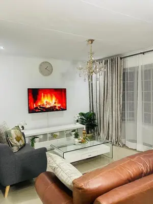 a living room with a couch and a fireplace at Beautiful Customized Hide Out in Centurion