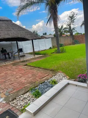 a patio with a table and a palm tree at Beautiful Customized Hide Out in Centurion