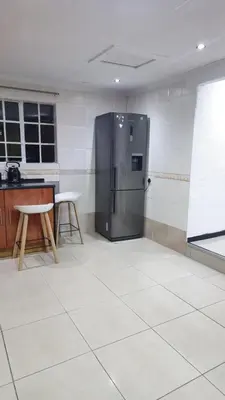 a kitchen with a stainless steel refrigerator in a room at Beautiful Customized Hide Out in Centurion