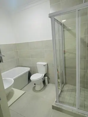 a bathroom with a toilet and a glass shower at HMT Modern House in Centurion