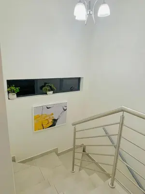 a staircase with a white wall with a window and plants at HMT Modern House in Centurion