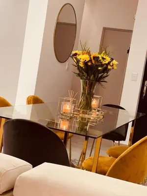 a glass table with a vase of flowers and candles at HMT Modern House in Centurion