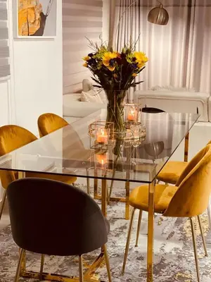 a glass table with yellow chairs and a vase of flowers at HMT Modern House in Centurion
