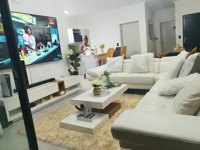 a living room with white couches and a flat screen tv at HMT Modern House in Centurion