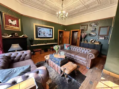 a living room with leather furniture and a chandelier at Villa 21 in Pretoria