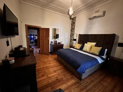 a bedroom with a bed and a desk and a television at Villa 21 in Pretoria