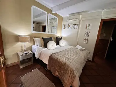 a hotel room with a bed and a mirror at Villa 21 in Pretoria