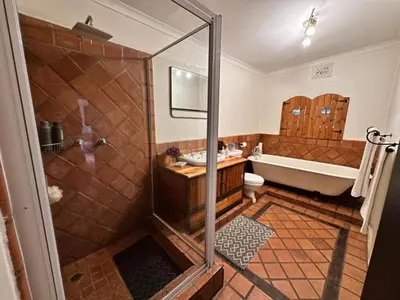 a bathroom with a shower and a tub and a sink at Villa 21 in Pretoria