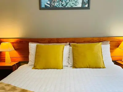 a bedroom with a bed with two yellow pillows at Hazyhaven Guest House in Hazyview