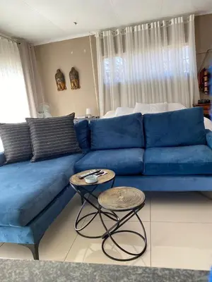 a blue couch with two tables in a living room at 2 Bedroom Cottage sleeps maximum 4 Buhlebendalo in Benoni