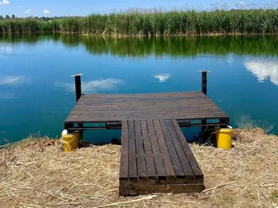 a wooden dock sitting in the middle of a lake at 2 Bedroom Cottage sleeps maximum 4 Buhlebendalo in Benoni
