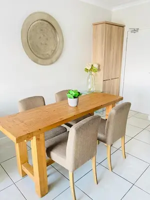 a wooden dining table with chairs and a plant on it at The Blyde SUPER STAR in Pretoria