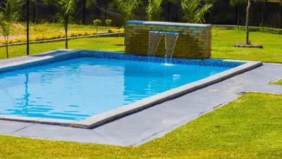 a swimming pool with a fountain in the grass at Thulamahashe Guest farm in Thulamahashi