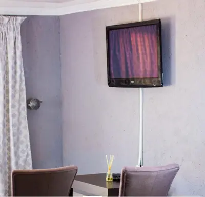 a table with two chairs and a television on a wall at Thulamahashe Guest farm in Thulamahashi