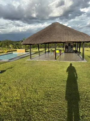 a shadow of a person standing in front of a gazebo at Thulamahashe Guest farm in Thulamahashi